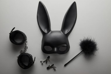top view of black rabbit mask and sex toys on white background clipart