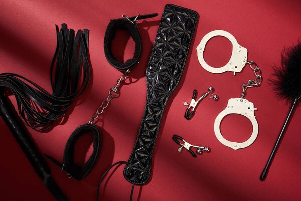 top view of black sex toys on red background