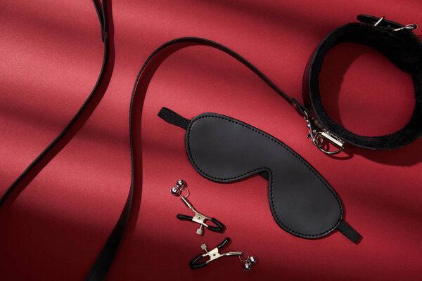 вид черных секс-игрушек на красном фоне
