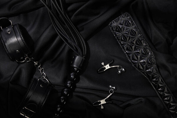 top view of sex toys on black textile background