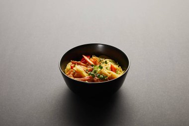 noodles with shrimps and vegetables in bowl on black background clipart