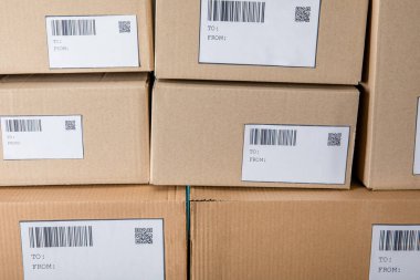 Stacked cardboard boxes with barcodes and qr codes on cards clipart