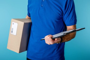 Dağıtım elemanının elinde pano ve karton paketin mavi üzerinde izole edilmiş görüntüsü