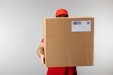 Gri kart üzerinde barkod ve qr kodu olan kapak tutucu kutusundaki kurye