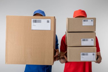 Elinde barkodlu karton paketler ve gri kartlarda QR kodları tutan teslimatçılar.