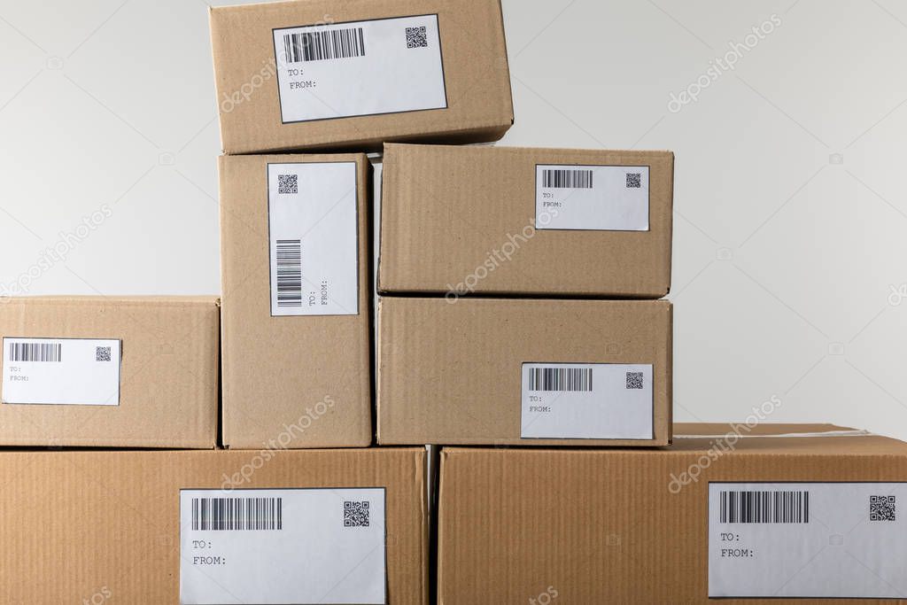 Cards with qr and barcodes on stacked cardboard boxes isolated on grey