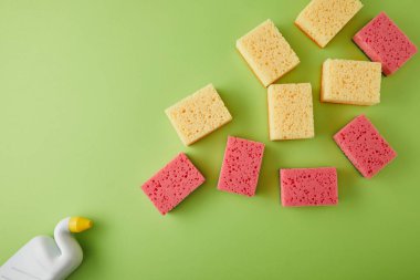 Pembe ve sarı sünger ve yeşil üzerine tuvalet temizleyicisi olan şişe manzarası.