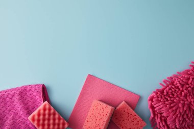 Pembe süngerlerin ve paçavraların üst manzarası mavi ev temizliği içindir.