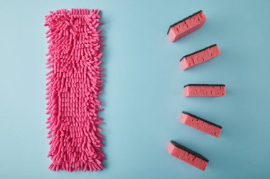 flat lay with pink rag and sponges for house cleaning on blue clipart