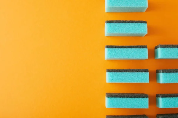Draufsicht Auf Blaue Schwämme Reihe Zum Spülen Auf Orange — Stockfoto
