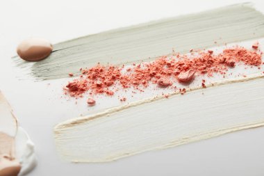 Kozmetik ve ton kremi, gri arka planda pembe allık ile kil fırça darbeleri