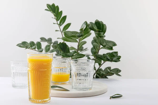 Vidro Delicioso Smoothie Amarelo Superfície Branca Perto Planta Verde Isolada — Fotografia de Stock