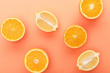 Top view of citrus fruits halves on orange background clipart