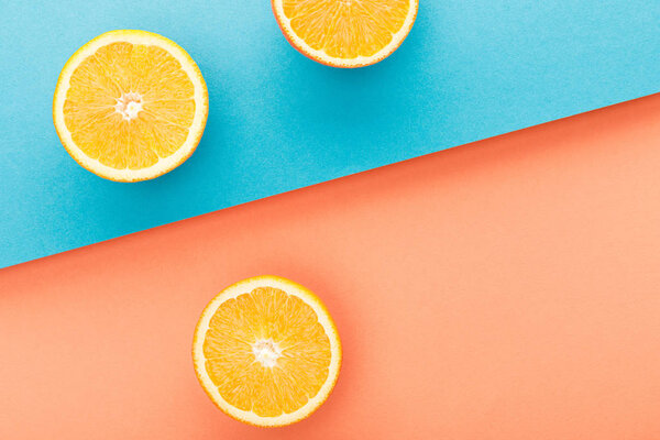 Top view of oranges halves on blue and orange background