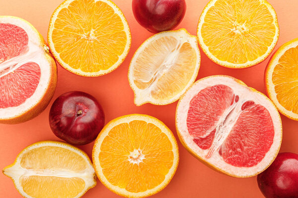Top view of citrus fruits halves and apples on orange background