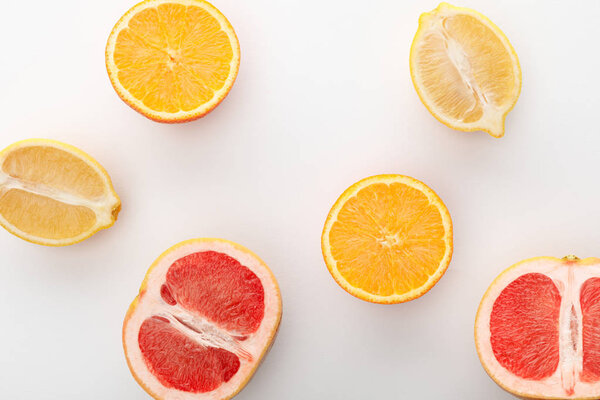 Top view of citrus halves on white background