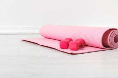 Spor paspası ve pembe dambıllar yere.