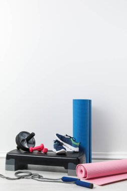 fitness mats, sneakers and sports stuff on floor at home   clipart