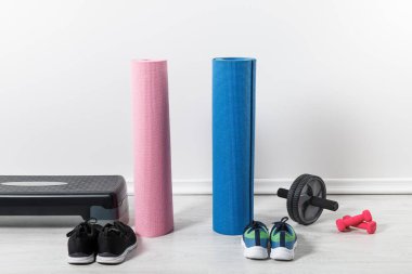 yoga minderleri, adım platformu ve spor malzemeleri evde yerde. 