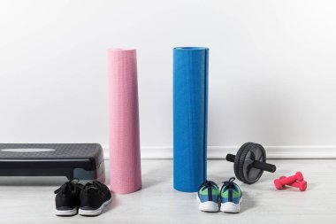 yoga mats, step platform and sport equipment on floor at home  clipart