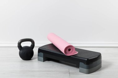 Adım platformu, kettlebell ve evde pembe fitness minderi. 