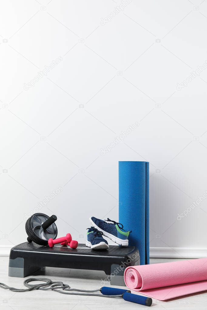 fitness mats, sneakers and sports stuff on floor at home  