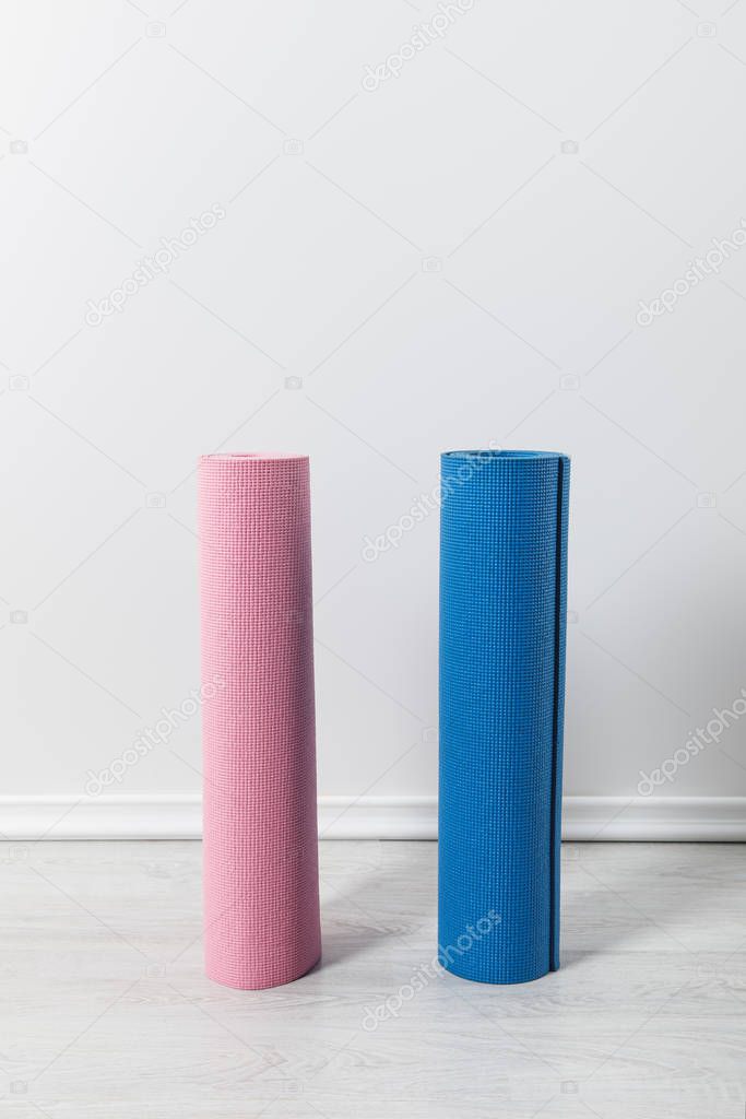 pink and blue fitness mats on floor at home 