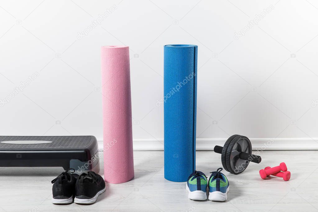 yoga mats, step platform and sport equipment on floor at home 