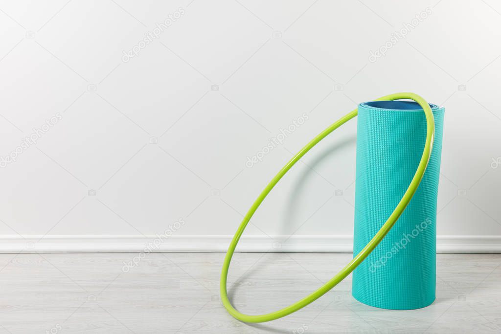 blue fitness mat and green dumbbells on floor at home