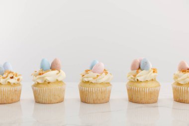 Tasty easter cupcakes isolated on grey clipart
