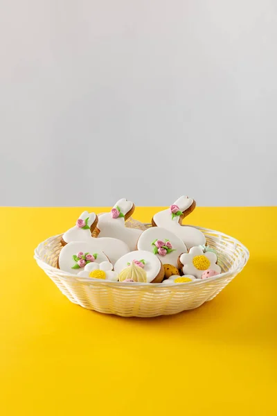 用灰色和黄色隔离的柳条篮中美味的饼干 — 图库照片