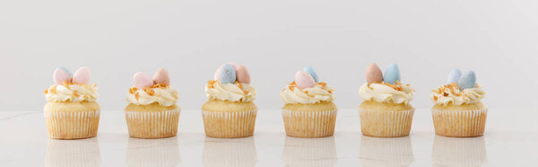 Delicious Easter cupcakes isolated on grey, panoramic shot