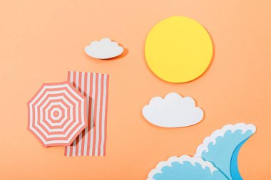 Top view of paper cut summer beach with umbrella and blanket on orange background clipart
