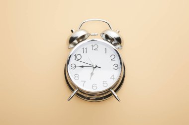 top view of classic alarm clock on beige background clipart