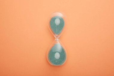 top view of hourglass on peach background clipart