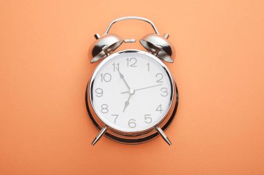 Şeftali arkaplanındaki klasik alarmlı saatin üst görünümü