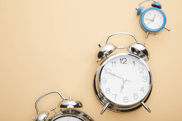 top view of classic alarm clocks on beige background