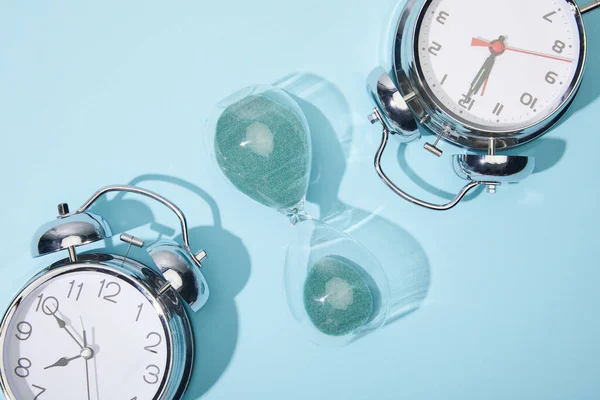 Vista Superior Relógios Alarme Clássicos Ampulheta Fundo Azul — Fotografia de Stock