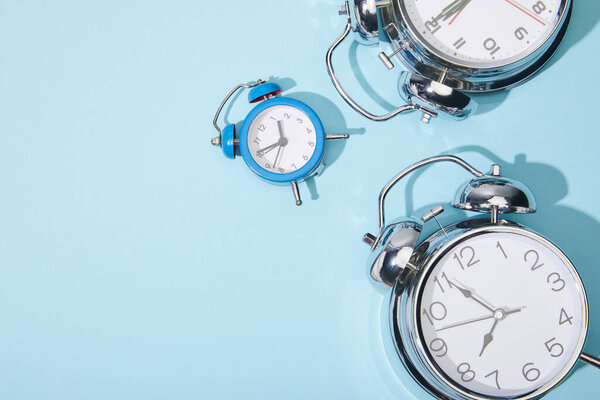 top view of classic alarm clocks on blue background