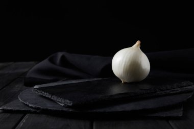 Tüm beyaz soğan siyah üzerine izole edilmiş siyah doğrama tahtaları 