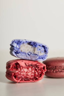 selective focus of assorted delicious bitten colorful french macaroons on white background clipart