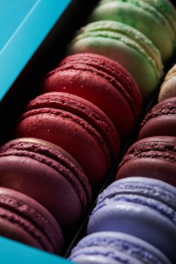 close up view of assorted delicious colorful french macaroons in box clipart