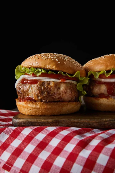 Twee Hamburgers Houten Snijplank Geruit Tafelkleed Geïsoleerd Zwart — Stockfoto