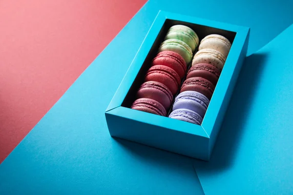 Assorted Delicious Bitten Colorful French Macaroons Box Blue Red Background — Stock Photo, Image