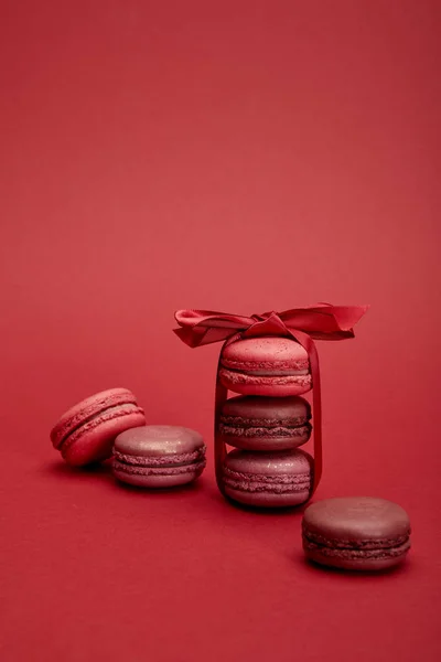 Deliziosi Macaron Francesi Colorati Avvolti Nastro Con Fiocco Sfondo Rosso — Foto Stock