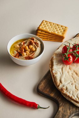 Humus, kraker, Pita ekmeği ve sebzelerle dolu bir kase.