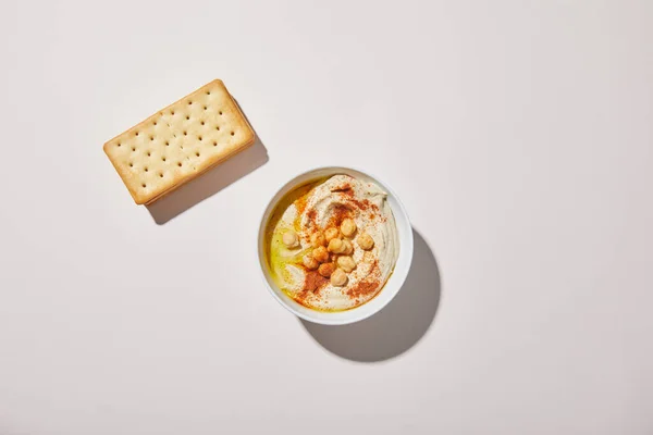 Bovenaanzicht Van Kom Met Lekkere Hummus Crackers Grijze Achtergrond — Stockfoto