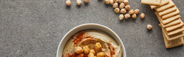 Boven Uitzicht Kom Met Heerlijke Hummus Kikkererwt Crackers Grijze Achtergrond — Stockfoto