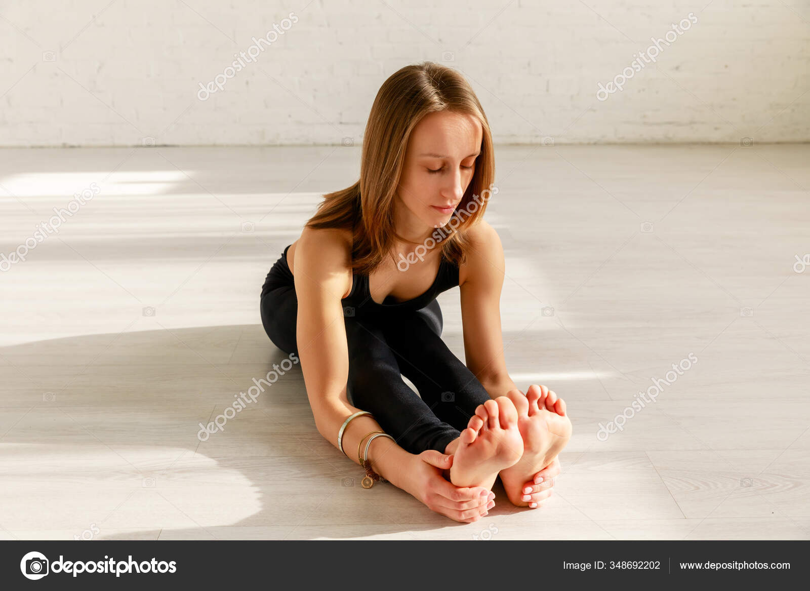 Attrayant Fille Avec Pieds Nus Étirement Sur Sol Dans Studio image