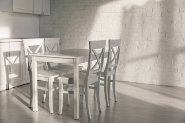 Modern mutfakta masanın yanındaki sandalyelerin yanındaki güneş ışığı. 